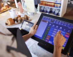 Close Up Of Female Employee Working At Delicatessen Checkout